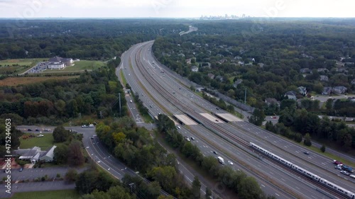 A 4k aerial video with an upward pan of a Silver Line Metro Train traveling down the Dulles Access Road with Tysons Corner in the distance. photo
