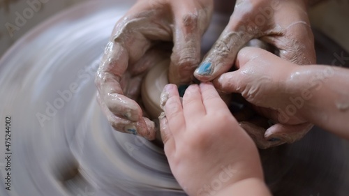 Close up of human hands. Pottery handcraft concentration, mother teaching toddler to moulding clay pot sculpture, art education for children 