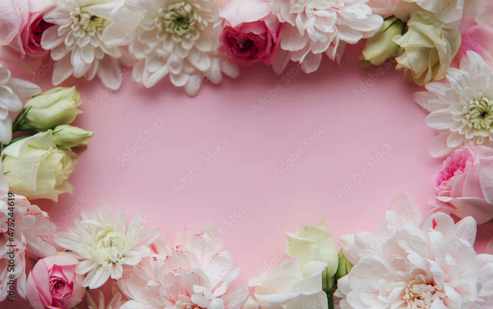 Frame made of flowers on pastel pink background.