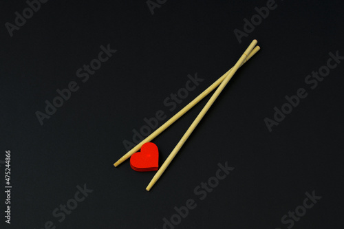 Valentine's Day card. Chopsticks, red hearts. Love, loveless black background. Lovers, Heartbreakers