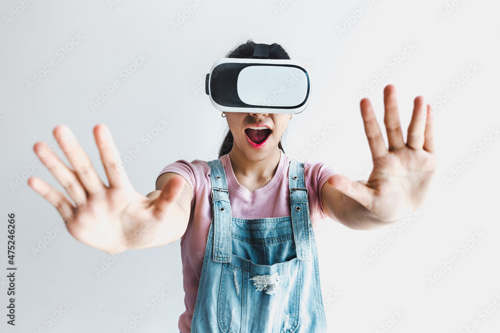 Young latin woman with glasses of virtual reality on a white background. Future technology concept. Modern imaging technology in Latin America Young latin woman with glasses of virtual reality on a white background. Future technology concept. Modern imaging technology in Latin America