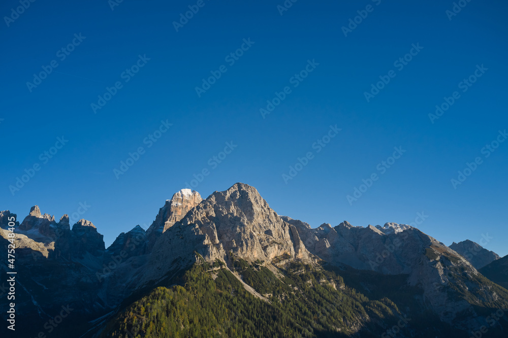 Autumn in the Italian Alps. Alps aerial view. Mountains in Europe top view. Forest plantations in the European Alps.