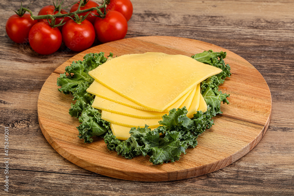 Sliced Gauda cheese over board Sliced Gauda cheese over board