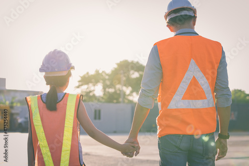 Father and daughter holding hand at Container cargo site. Business heir concept. 
