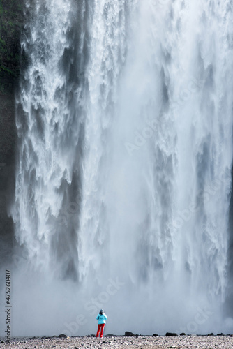 Woman admiring Skogafoss waterfall in Iceland