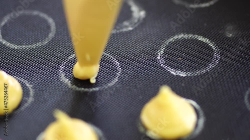 Pastry chef squeezes choux au craquelin from a pastry bag on a silicone mat photo