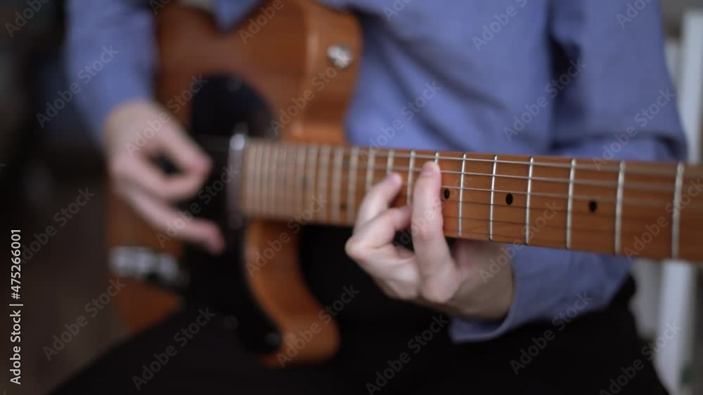 Guitar player hands playing telecaster with pick. A simple riff on