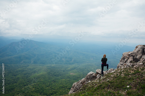 woman traveler looks at the beautiful landscape from the top of the mountain © dmitriisimakov
