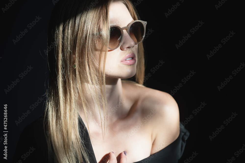 Fashion model in sunglasses with beauty face. Tender woman on black dark background. Tenderness concept. Tenderness womans look. Fashion model in sunglasses with beauty face. Tender woman on black dark background. Tenderness concept. Tenderness womans look.