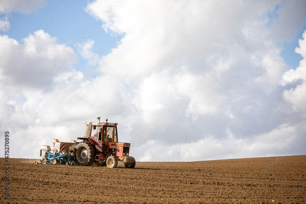 Obraz premium Agriculture en France, vieux tracteur labourant son champ au printemps.