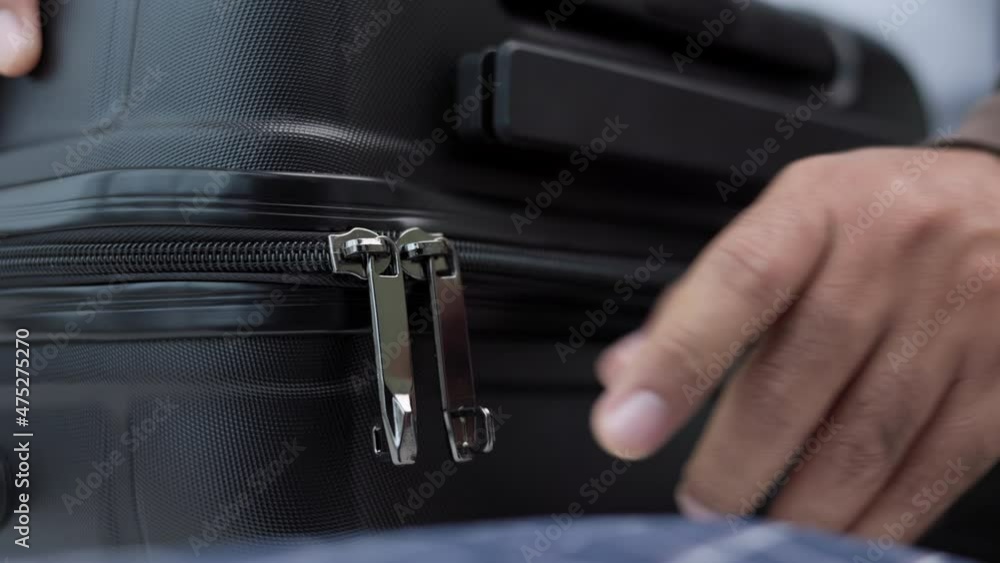 Close up male hand organize luggage. Hand zipping to close luggage suite case. Packing for trip in holiday travel vacation. Close up male hand organize luggage. Hand zipping to close luggage suite case. Packing for trip in holiday travel vacation.