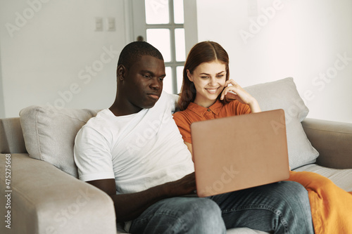 Cheerful man and woman with laptop at home relaxing communication