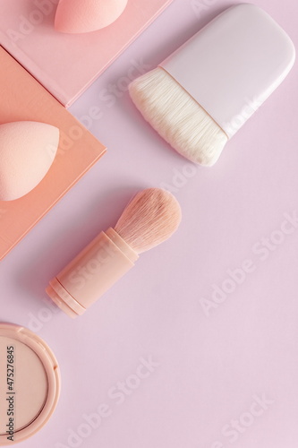 Makeup accessories, brushes and sponges,pink pastel background,flat layot