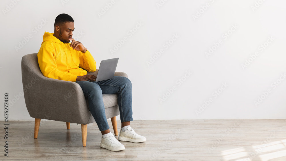 African American Man Using Laptop Thinking Working Online, Gray Background