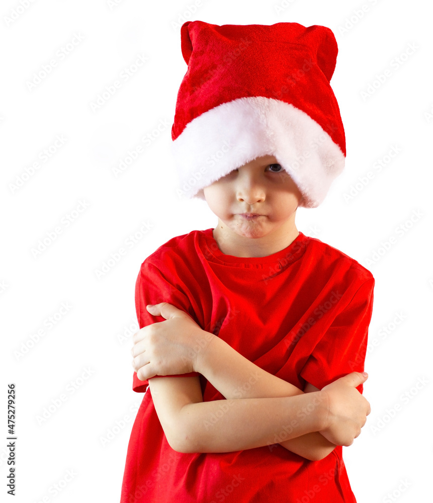 portrait of a little boy in a hat of Santa Claus stands on a white background looking angrily at the camera, failed new year for a child, bad gifts portrait of a little boy in a hat of Santa Claus stands on a white background looking angrily at the camera, failed new year for a child, bad gifts