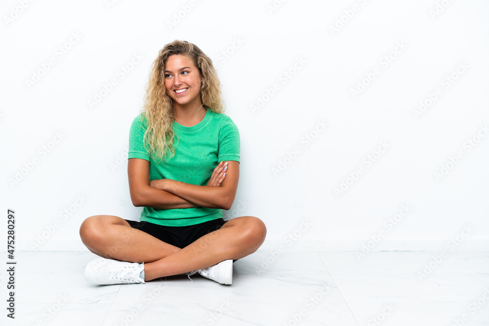 Girl with curly hair sitting on the floor with arms crossed and happy Girl with curly hair sitting on the floor with arms crossed and happy