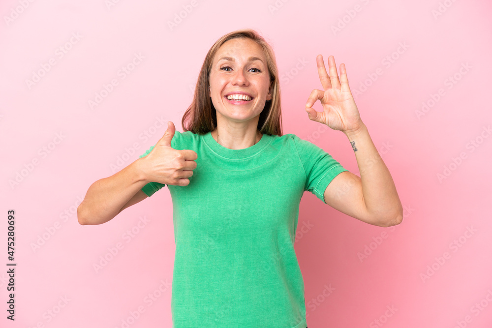 Young English woman isolated on pink background showing ok sign and thumb up gesture Young English woman isolated on pink background showing ok sign and thumb up gesture