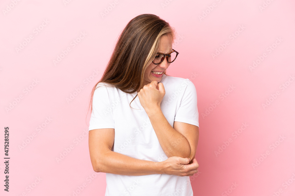 Young English woman isolated on pink background with pain in elbow Young English woman isolated on pink background with pain in elbow
