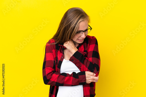 Young English woman isolated on yellow background with pain in elbow