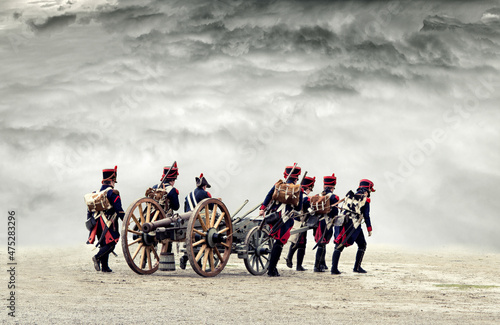 Napoleonic soldiers marching in open plain land with dramatic clouds., pulling a cannon. No recognizable people in the scene.