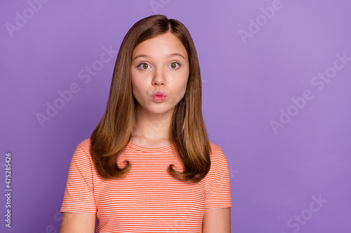 Portrait of attractive affectionate funky brown-haired girl sending air kiss isolated over vibrant violet purple color background