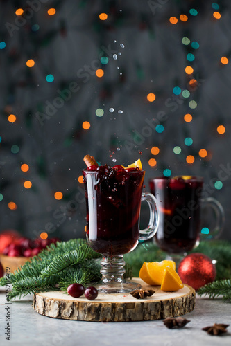 Splash from a bakal with mulled wine against a background of Christmas lights photo