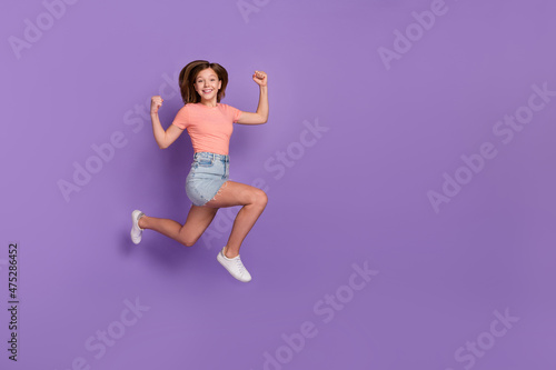 Full length body size view of lovely cheery trendy girl jumping showing strength running isolated on bright violet purple color background