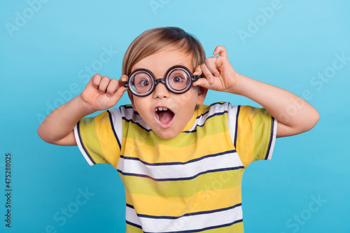 Fotografia Portrait of attractive funky amazed cheerful boy wearing thick specs isolated ov
