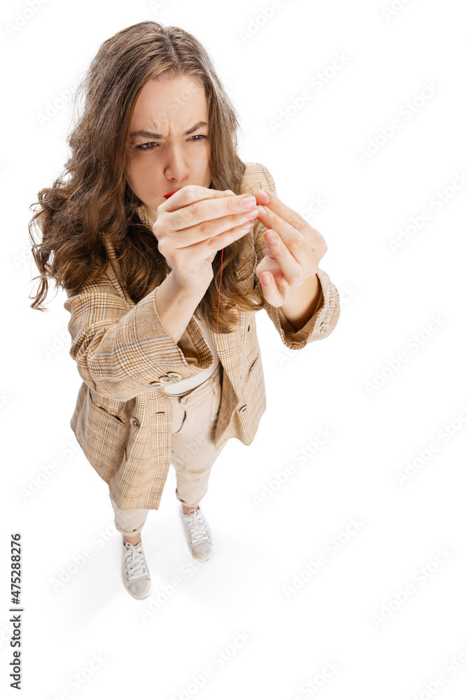 Close-up portrait of smiling young girl, dressmaker posing isolated on white background. Concept of job, hobby Close-up portrait of smiling young girl, dressmaker posing isolated on white background. Concept of job, hobby