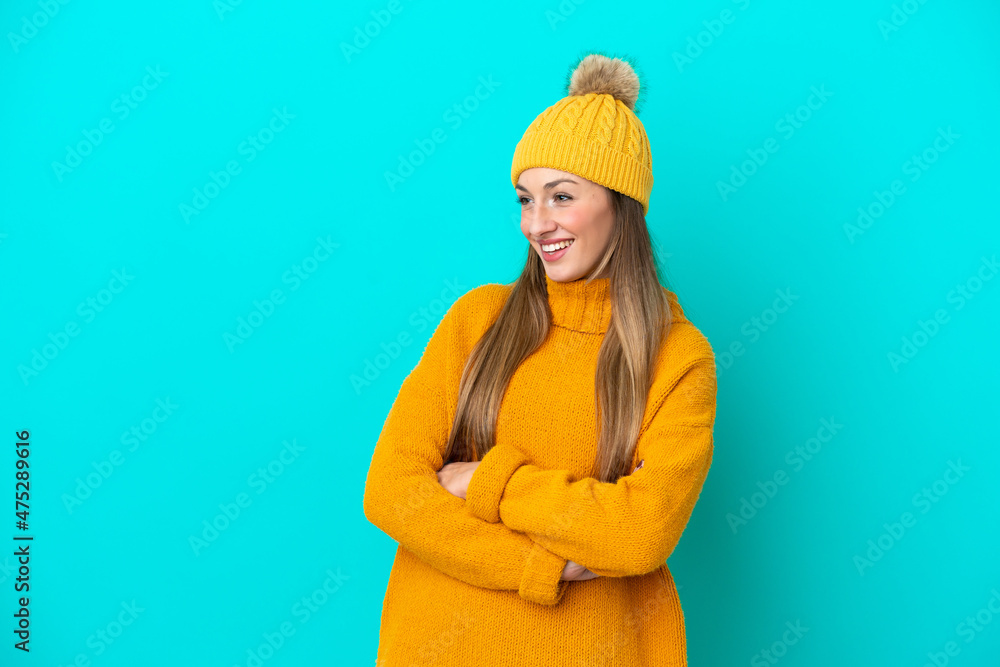 Young caucasian woman wearing winter jacket isolated on blue background happy and smiling