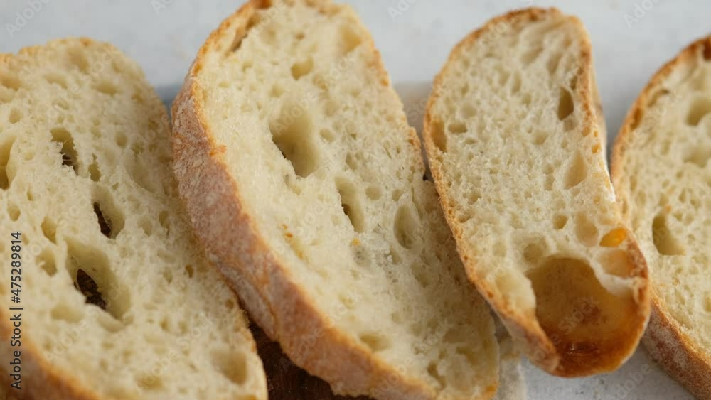Camera movement. Top view. Sliced bread lies on a wooden board. Baking bread. Cooking the ciabatta. Italian bread. Camera movement. Top view. Sliced bread lies on a wooden board. Baking bread. Cooking the ciabatta. Italian bread.