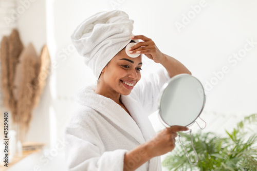 Black Woman Doing Facial Skincare Routine In Bathroom At Home