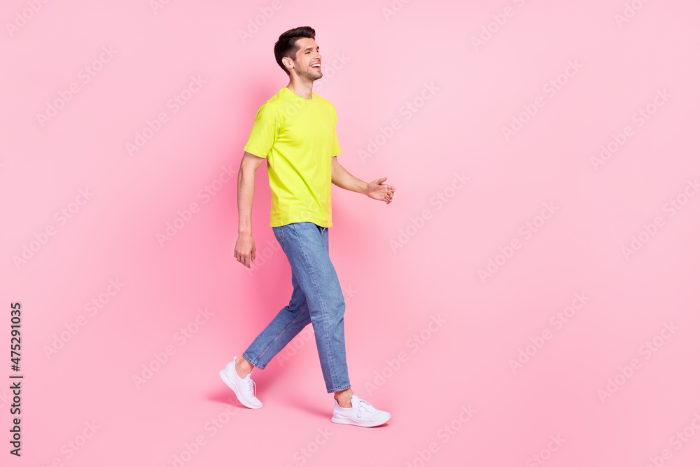 Full length body size photo man smiling in stylish outfit walking forward looking copyspace isolated pastel pink color background Full length body size photo man smiling in stylish outfit walking forward looking copyspace isolated pastel pink color background