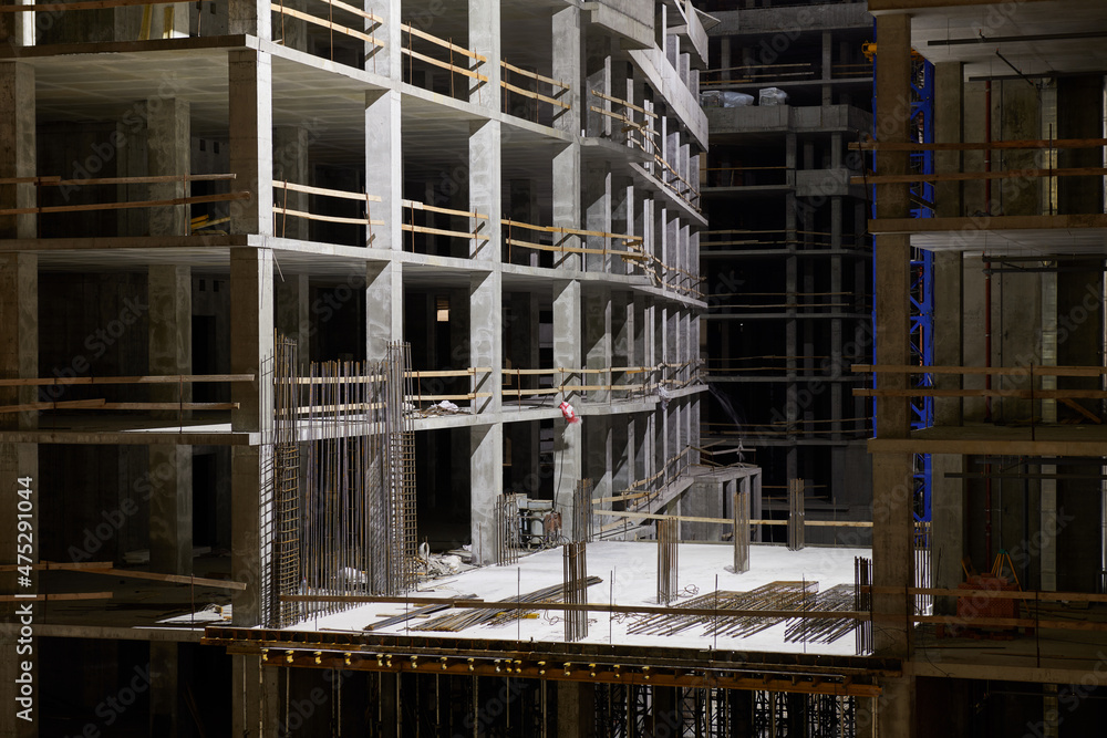 Building site at night. Construction in the city. Multi-storey building or office center. Horizontal photo.