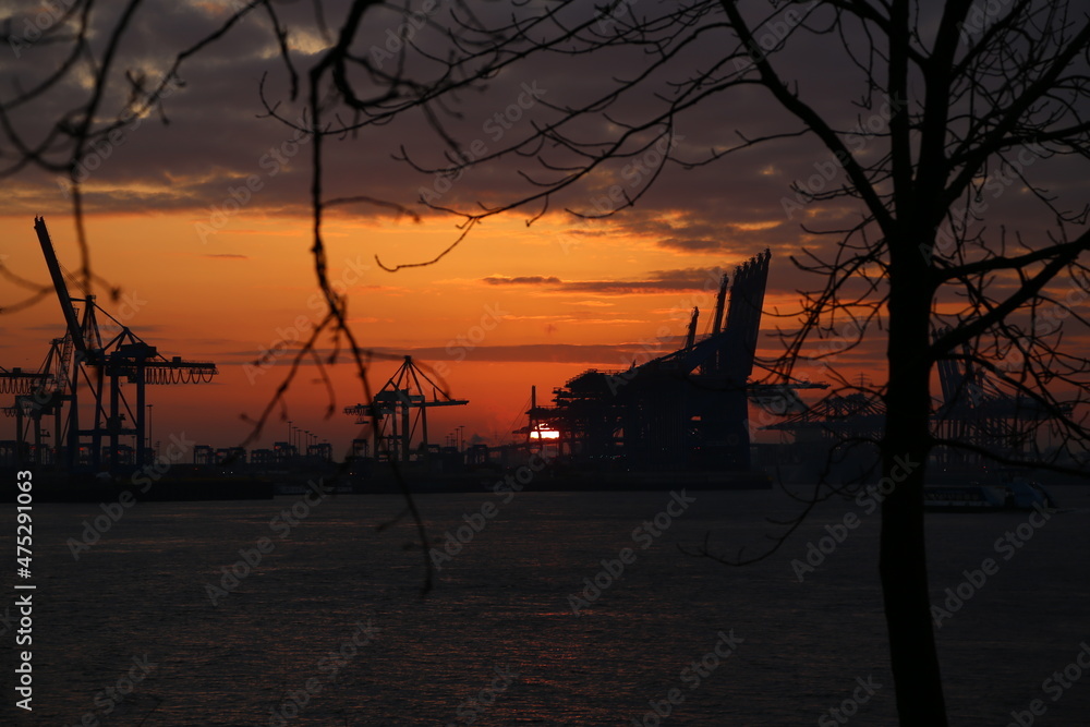 Dunkler Oranger Sonnenaufgang über den Hamburger Hafen im Herbst