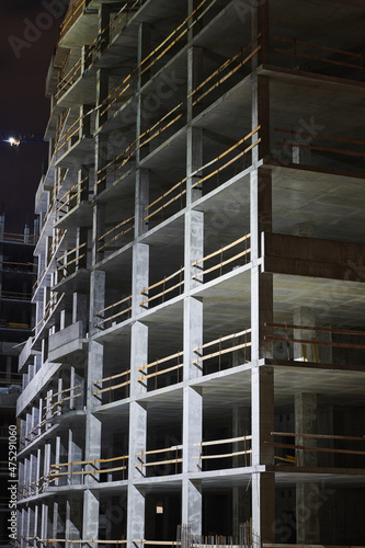 Building site at night. Construction in the city. Multi-storey building or office center. Horizontal photo.
