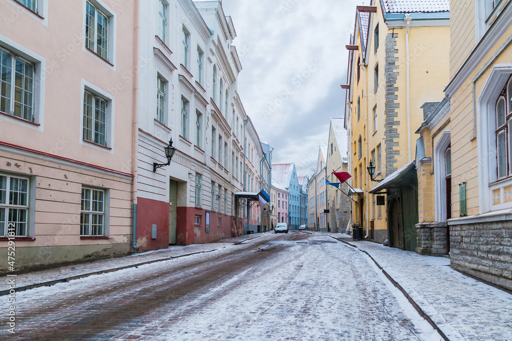 Perspective view of old buildings on the Pikk Street in overcast winter day, Tallinn Old Town, Estonia
