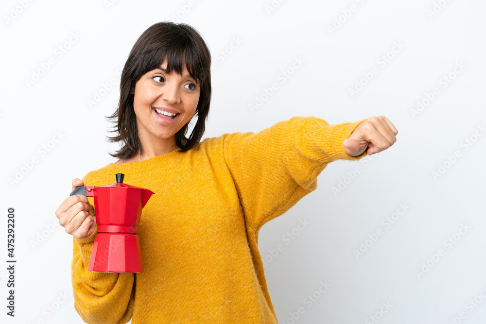 Young mixed race woman holding coffee pot isolated on white background giving a thumbs up gesture Young mixed race woman holding coffee pot isolated on white background giving a thumbs up gesture