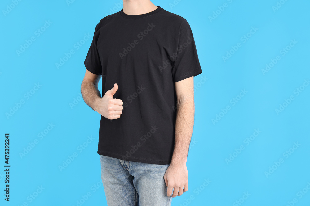 Man in blank black t-shirt on blue background Man in blank black t-shirt on blue background