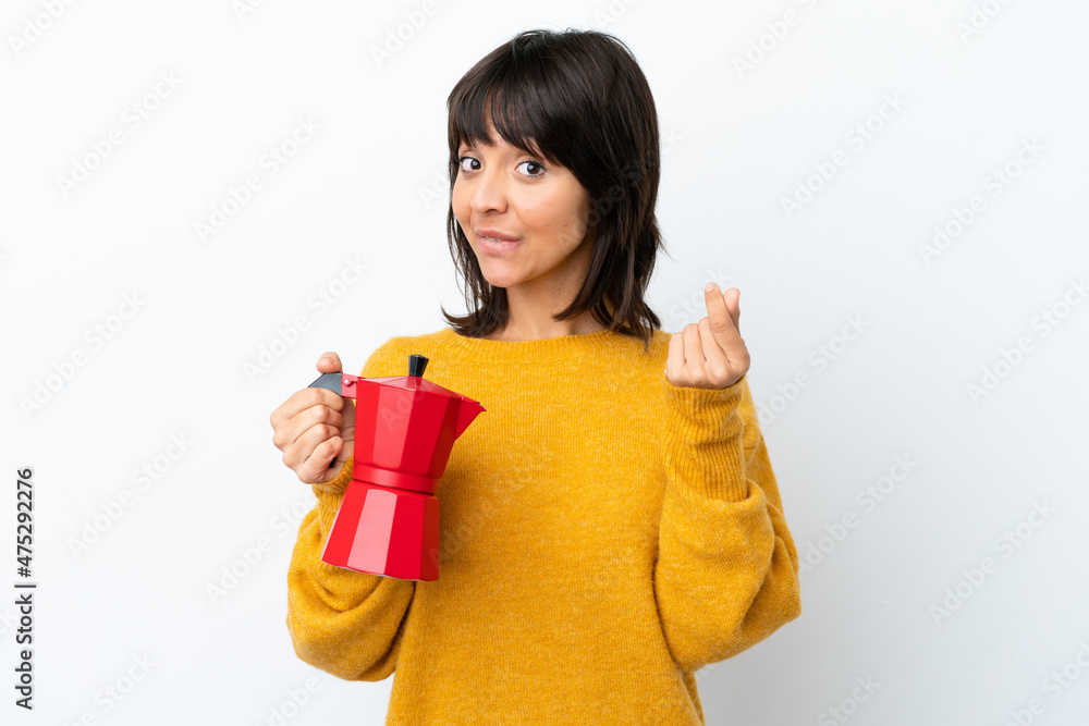 Young mixed race woman holding coffee pot isolated on white background making money gesture Young mixed race woman holding coffee pot isolated on white background making money gesture