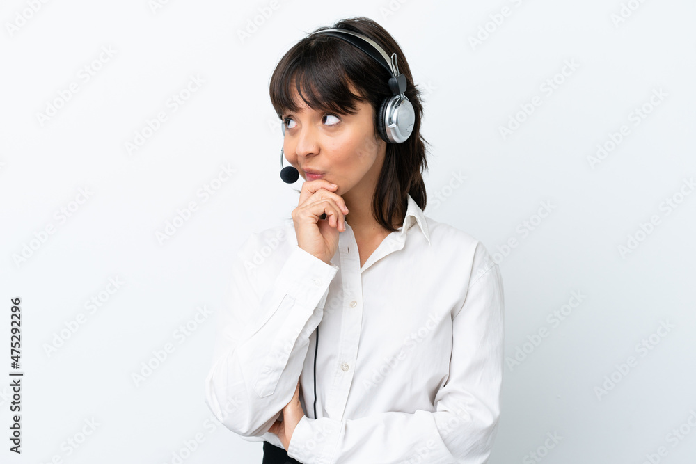 Telemarketer mixed race woman working with a headset isolated on white background having doubts and with confuse face expression Telemarketer mixed race woman working with a headset isolated on white background having doubts and with confuse face expression