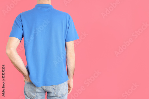 Man in blank blue polo on pink background
