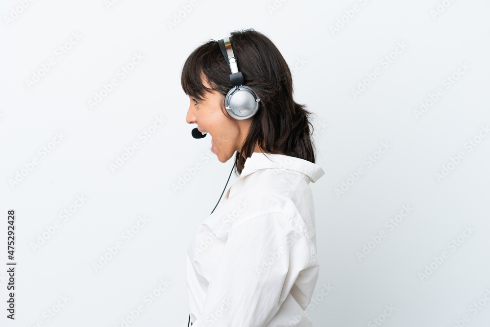 Telemarketer mixed race woman working with a headset isolated on white background laughing in lateral position Telemarketer mixed race woman working with a headset isolated on white background laughing in lateral position