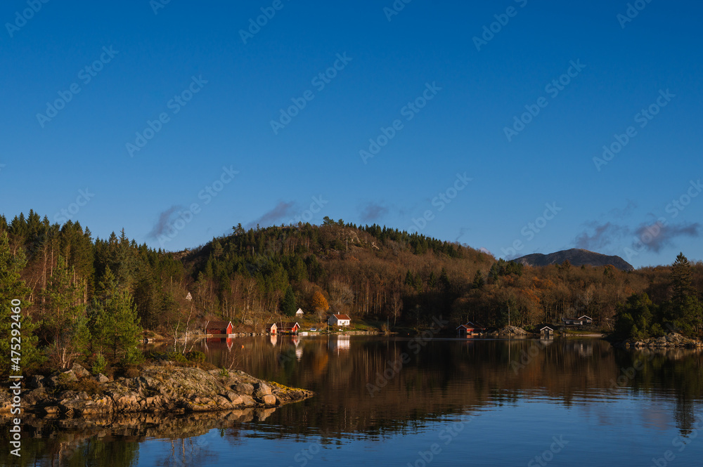 Scenic landscape of village on the fjord and mountains. Beautiful nature of Norway at sunny autumn day. Lusefjord.