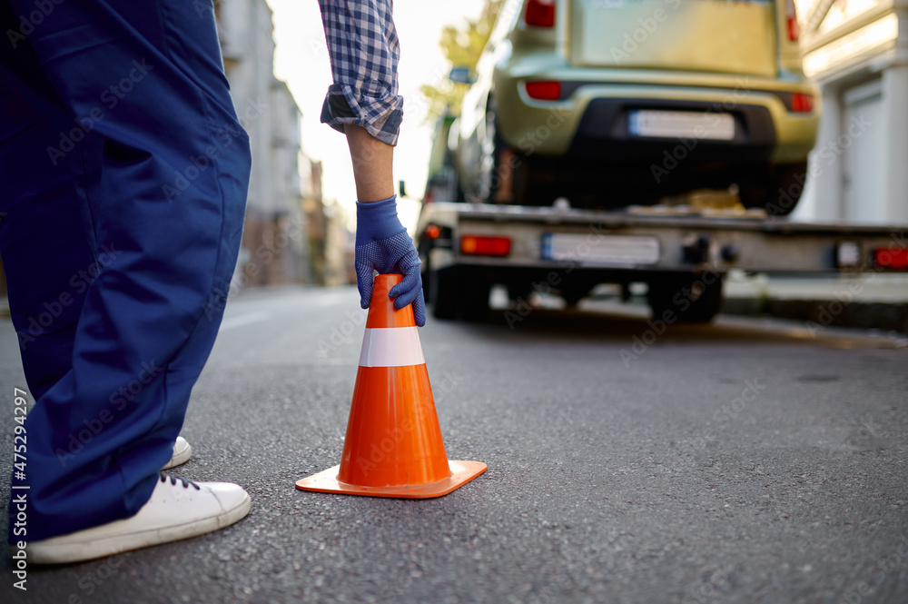 Fototapeta premium Road worker putting traffic cone on roadside