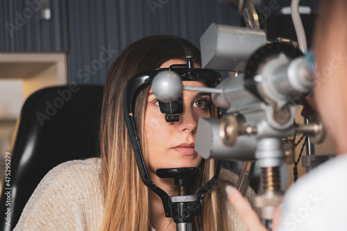 an optician measures a girl's corneal radii with a keratometer in a clinic. photo