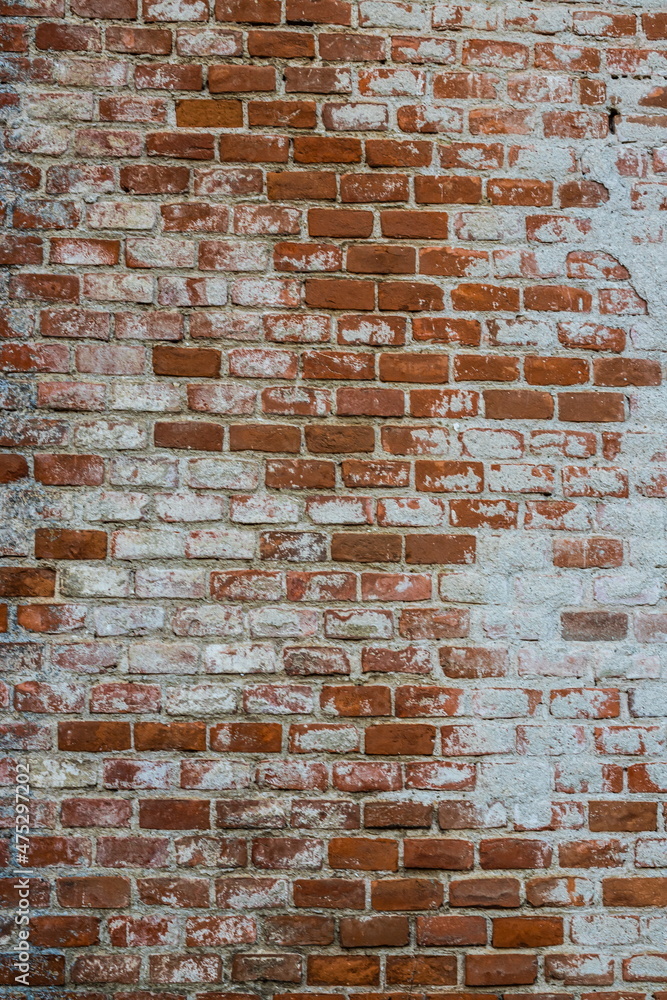 Naklejka premium Background of old vintage dirty brick wall with peeling plaster, texture