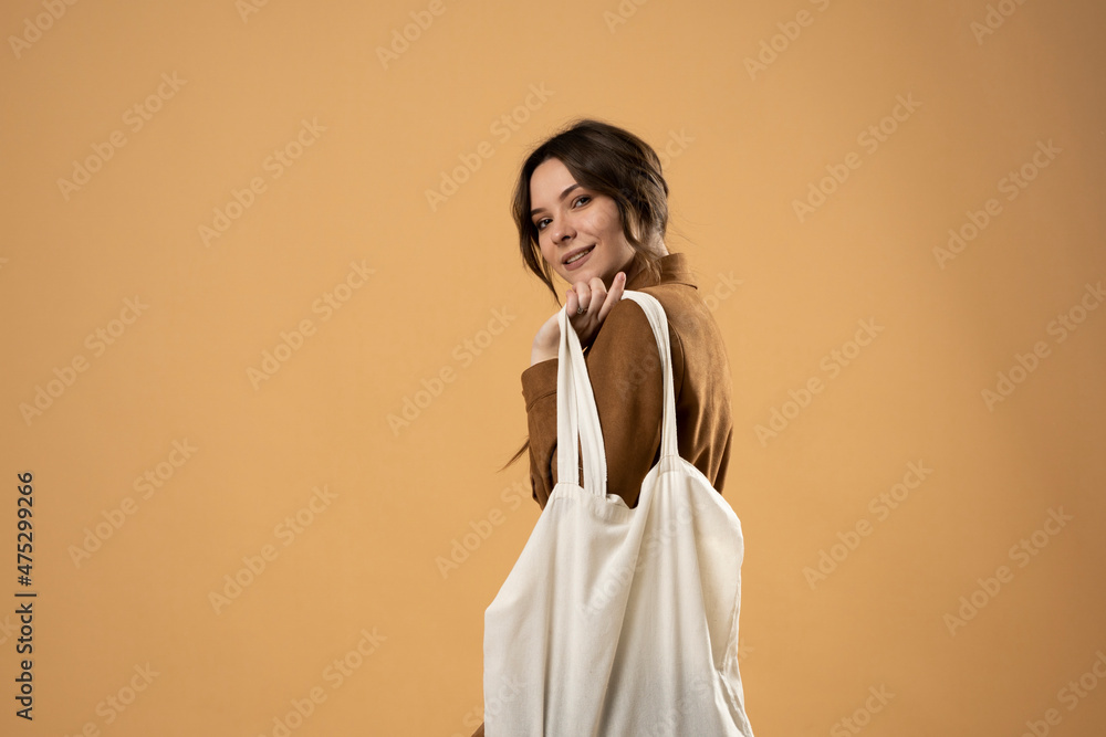Woman holding white cotton grocery bag. Reusable eco bag for shopping. Zero waste concept. Eco friendly lifestyle. Isolated white background. Mockup. Cropped. Woman holding white cotton grocery bag. Reusable eco bag for shopping. Zero waste concept. Eco friendly lifestyle. Isolated white background. Mockup. Cropped.