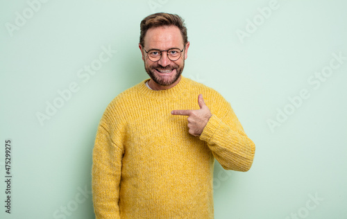 middle age handsome man looking happy, proud and surprised, cheerfully pointing to self, feeling confident and lofty