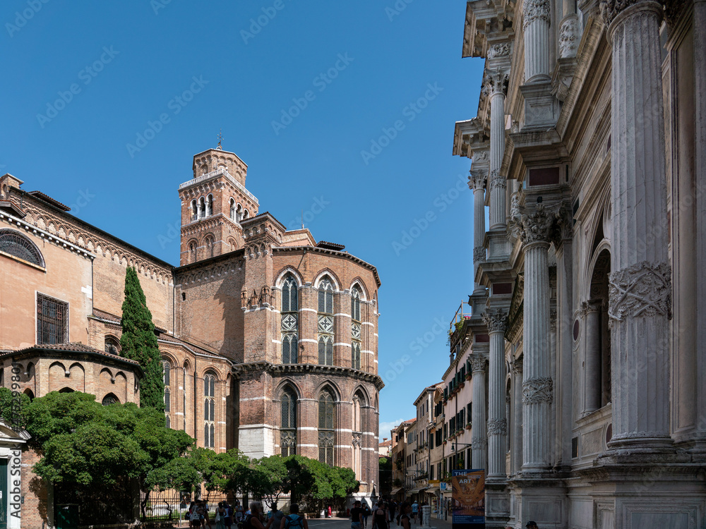 Scuola San Rocco with Frari church in Venice on piazza with green trees